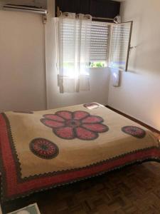 a bedroom with a bed with a flower on it at Cómodo apartamento en Colonia, cerca de todo in Colonia del Sacramento