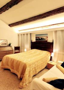 a bedroom with a large bed and a chair at Ca' Spendore del Sole in Venice