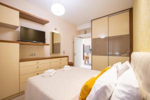 a bedroom with a white bed and a television at Corfu Dream Home in Corfu Town