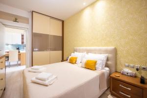 a bedroom with a large white bed with yellow pillows at Corfu Dream Home in Corfu Town