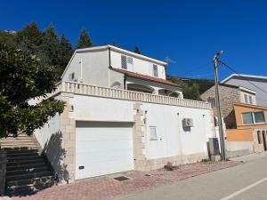 a white building with a white garage door at Villa M in Neum