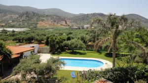 a villa with a swimming pool and mountains in the background at Ibiscus Hotel Malia in Malia
