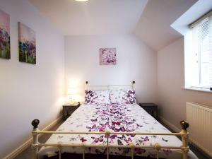Un dormitorio con una cama con flores rosas. en Rose Cottage en Conwy
