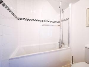 La salle de bains blanche est pourvue d'une baignoire et de toilettes. dans l'établissement Rose Cottage, à Conwy