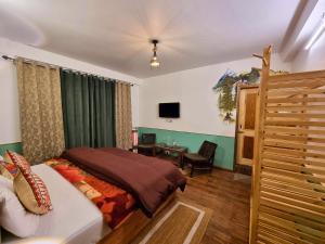 a bedroom with a bed and a desk and a television at The Bunker Burwa Manali in Manāli