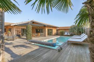 um quintal com uma piscina e uma casa em Villa privée 12 personnes piscine chauffée - ARES em Arès