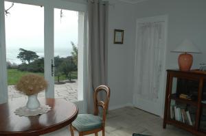 Cette chambre dispose d'une table avec un vase de fleurs. dans l'établissement La Criste Marine, à Groix