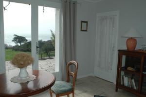 a room with a table with a vase of flowers on it at La Criste Marine in Groix