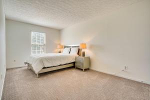 GahannaにあるSpacious Home with Deck - 9 Mi to Downtown Columbusの白いベッドルーム(ベッド1台、窓付)