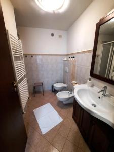 uma casa de banho com um lavatório, um WC e um espelho. em N. & A. Sweet Home em Lucca