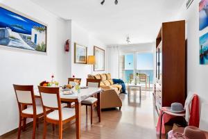 a dining room and living room with a table and chairs at Apartment Barlovento 2 - PlusHolidays in Calpe