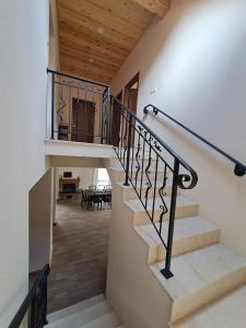 uma escadaria com um corrimão de ferro forjado e um estojo de escadas em Тиловите къщи em Ribarica