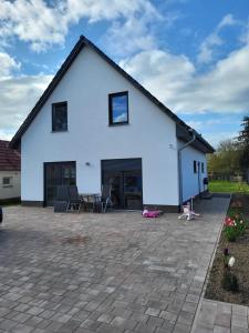 a white house with chairs and a patio at Haus für vier, kinderfreundlich! in Steinhagen
