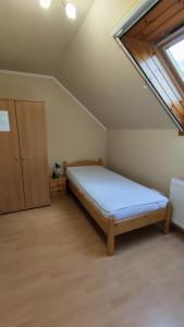 um quarto com uma cama num quarto com uma janela em Vascsacsi Nyaraló em Orosháza