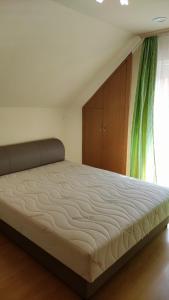 ein großes Bett in einem Schlafzimmer mit Fenster in der Unterkunft Vascsacsi Nyaraló in Orosháza