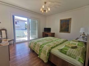 1 dormitorio con 1 cama con edredón verde en Pri Noni "IstraCycle" en Lucija