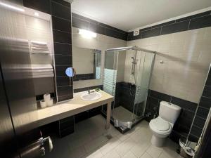 a bathroom with a toilet and a shower and a sink at Village Mare Residences in Kalyves Poligirou +22 photos