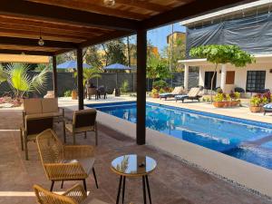 una piscina con sillas y una mesa junto a una casa en Natura Hotel & Villas, en Zihuatanejo