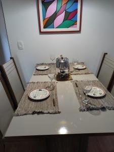 uma mesa com pratos e copos de vinho em Apartamento confortavel Centro de Teresopolis. NOVO em Teresópolis
