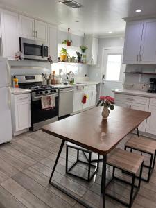 a kitchen with a table and a kitchen with white cabinets at Private Room in Los Angeles LA with TV & WIFI & AC & View of Hollywood Sign & Private Fridge & Shared Kitchen!!! in Los Angeles