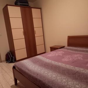 a bedroom with a bed and a dresser and a closet at Ksenija apartman uz more in Krasici