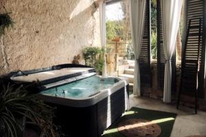 uma banheira de hidromassagem sentada fora de uma casa em Le Mas Réolais em Saint-Sève