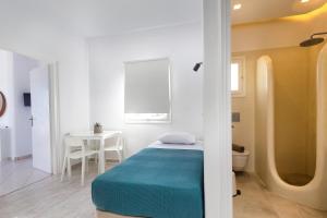 a small bedroom with a bed and a table at La Mer Seaside Apartments in Drios