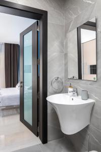 a bathroom with a sink and a mirror at Modern 3BR Stylish Apartment with large Balcony - Close to St Julians and St Georges Bay in Is-Swieqi