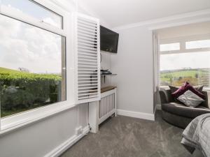 1 dormitorio con ventana, sofá y TV en The Hideaway en Kingsbridge