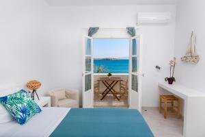 1 dormitorio con cama y vistas al océano en La Mer Seaside Apartments, en Drios