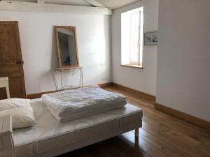 Habitación blanca con cama y espejo en Maison de ville confortable 200m de la mer, en Le Château-dʼOléron