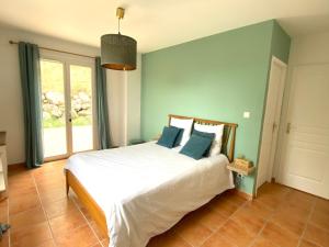 een slaapkamer met een groot bed met blauwe muren bij L’oustau in Rochefort-du-Gard