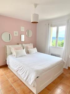 1 dormitorio con 1 cama blanca grande con almohadas blancas en L’oustau, en Rochefort-du-Gard