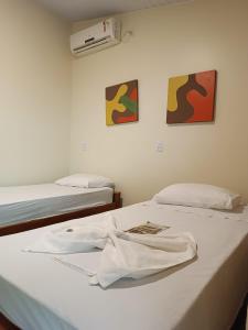 a room with two beds and a shirt on a bed at Pousada Águas do Jalapão in Ponte Alta do Norte