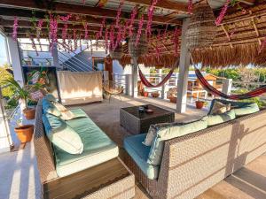 a patio with two wicker chairs and a table at Costa Nube in Caye Caulker