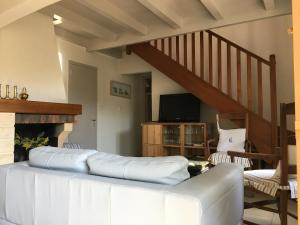 a living room with a couch and a staircase at Mon Dada 150m de la plage, climatisee in Saint-Georges-dʼOléron