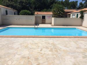 a large swimming pool in a yard with a house at La maisonnette des vacances in Saint-Georges-dʼOléron