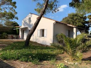 a white house with a tree in front of it at Mon Dada 150m de la plage, climatisee in Saint-Georges-dʼOléron