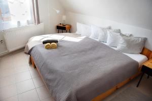 Un dormitorio con una cama grande con dos pares de zapatos. en Valentin ház en Szentendre