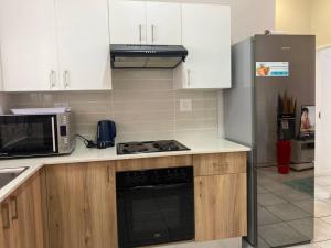 a kitchen with a stove and a microwave at Greenpark Lifestyle Estate in Boksburg