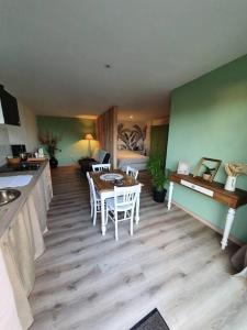 a living room with a table and a couch at Charmant appartement au calme in Saint-Romain-la-Motte