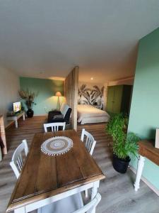 a room with a wooden table and a bedroom at Charmant appartement au calme in Saint-Romain-la-Motte