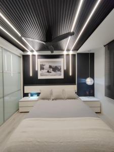 1 dormitorio con 1 cama grande y techo negro en Bungalows del Golf Almerimar en Almerimar