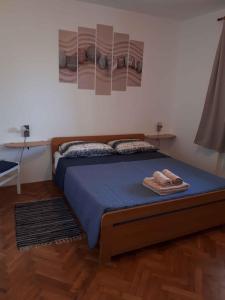 a bedroom with a bed with blue sheets and two towels at Apartment Valbandon, Istria 6 in Valbandon