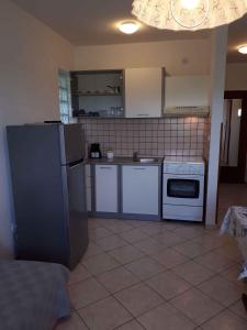 a kitchen with white appliances and a tile floor at Apartment Valbandon, Istria 6 in Valbandon