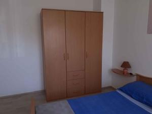 a bedroom with a bed and a wooden cabinet at Apartment Valbandon, Istria 5 in Valbandon