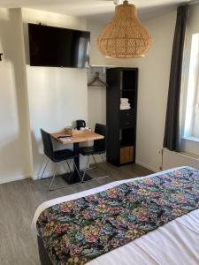 een slaapkamer met een bed en een tafel met stoelen bij B&B De Hofnar Roermond in Roermond