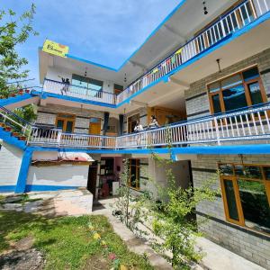 un edificio con un balcón con gente. en The Bunker Burwa Manali, en Manali