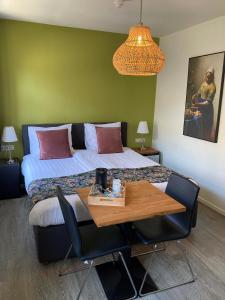 a bedroom with a bed and a table with chairs at B&B De Hofnar Roermond in Roermond