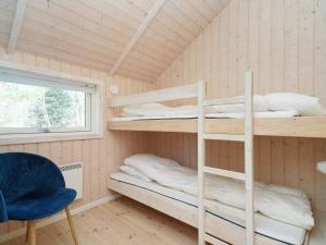 LumsåsにあるThree-Bedroom Holiday home in Nykøbing Sj 4の二段ベッド、椅子、窓が備わる客室です。